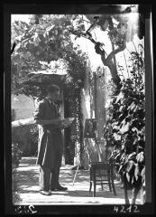[Portrait d'un peintre : homme peignant son tableau en extérieur sur une terrasse]. - [fin des années 1930-1940].