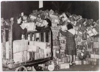 [Femmes triant des colis à destination des travailleurs] / photographie Agence Trampus, bureau de Vichy. - 9 décembre 1942. - Photographie