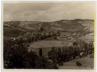 Saint-Izaire (Aveyron) : village (bâti en amphithéâtre autour du gros château des évêques de Vabres) et paysage (champs, collines) / J.-E. Auclair photogr. - [entre 1920 et 1950]. - Photographie