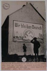 Propagande allemande dans les rues de la Sarre. Dans tous les villages, le front allemand a fait placarder ces affiches : "Nous resterons allemands" / photographie Meurisse, Paris [copyright BNF]. - 3 décembre 1934. - Photographie