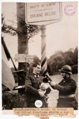 A la frontière franco-belge. Un soldat belge, au poteau frontière, montre à son collègue français la mascotte qu'il vient d'adopter / photographie Agence Trampus, Paris. - 2 octobre 1939. - Photographie