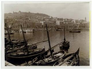 Sète (Hérault) : le port (bateaux à l'amarre) et la ville (sur les hauteurs, citadelle Richelieu et à droite, église décanale Saint-Louis) / J.-E. Auclair photogr. - [entre 1920 et 1950]. - Photographie