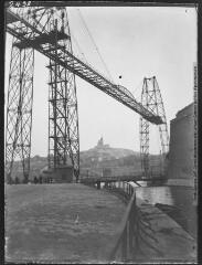 Marseille : Notre Dame de la Garde vue à travers le pont transbordeur / cliché Charles-Jacques Brunet. - 1912.