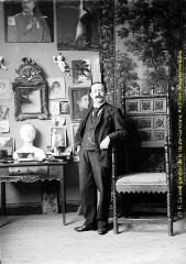 Portrait en intérieur d'un homme dans une pièce richement décorée. - [entre 1900 et 1920]. - Photographie