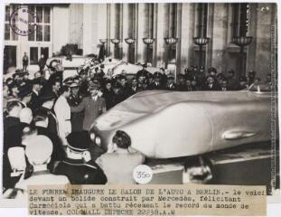 Le Führer inaugure le salon de l'auto à Berlin : le voici devant un bolide construit par Mercedès, félicitant Caracciola [pilote coureur automobile et moto] qui a battu récemment le record du monde de vitesse / photographie Keystone, Paris. - 19 février 1938. - Photographie