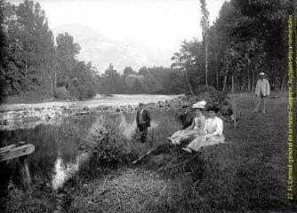 Groupe en pose au bord de l'eau, dans un paysage de montagne. - [entre 1900 et 1920]. - Photographie