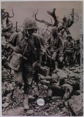 Dans l'île d'Okinawa, des fusiliers marins américains passent devant le cadavre d'un soldat japonais tué au cours des violents combats qui se sont déroulés dans la partie sud de l'île / photographie Stella-Presse, Paris. - 22 février 1945. - Photographie