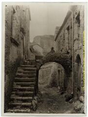 Hameau de Boussagues (La-Tour-sur-Orb, Hérault) : arc reliant deux maisons de pierre dans une ruelle / J.-E. Auclair photogr. - [entre 1920 et 1950]. - Photographie