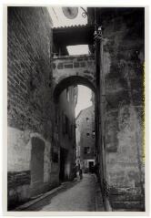 Pézenas (Hérault) : rue Triperie-Vieille : arc portant passage sur rue entre deux maisons / photographie L. Truel, marché des 3/6, Pézenas (Hérault). - [entre 1920 et 1950]. - Photographie