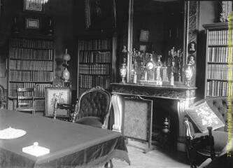 1 vue - Cheminée et bibliothèque : pièce d\'un château. - [entre 1900 et 1920]. - Photographie (ouvre la visionneuse)