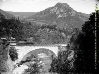 1 vue - Passage du train sur un pont dans un paysage de montagne. - [entre 1900 et 1920]. - Photographie (ouvre la visionneuse)