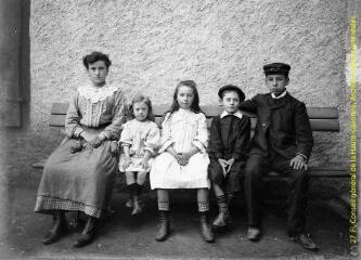 1 vue - Portrait en extérieur d\'une jeune fille et de quatre enfants assis sur un banc. - [entre 1900 et 1920]. - Photographie (ouvre la visionneuse)