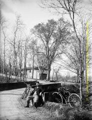 1 vue - Un homme assis et deux bicyclettes près d\'un pont. - [entre 1900 et 1920]. - Photographie (ouvre la visionneuse)