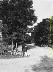 1 vue - Un homme assis et une bicyclette près d\'un pont. - [entre 1900 et 1920]. - Photographie (ouvre la visionneuse)