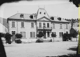 1 vue - Place d\'un village : bâtiment des écoles et de la mairie. - [entre 1900 et 1920]. - Photographie (ouvre la visionneuse)