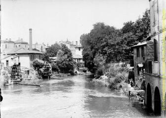 1 vue - Rivière traversant un village : deux moulins avec roue à eau et pêcheurs à la ligne. - [entre 1900 et 1920]. - Photographie (ouvre la visionneuse)