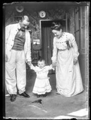 1 vue  - Portrait d\'un couple tenant un enfant par la main (intérieur maison). - [entre 1890 et 1920]. - Photographie (ouvre la visionneuse)
