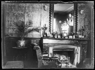 1 vue  - Intérieur de la maison Mauran : fauteuil et cheminée. - [entre 1901 et 1909]. - Photographie (ouvre la visionneuse)