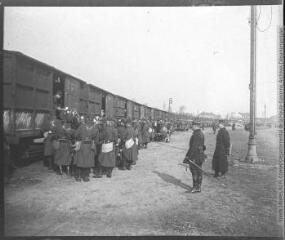 1 vue - Arras (24 février 1909). [Embarquement de la compagnie dans des wagons de marchandises]. (ouvre la visionneuse)