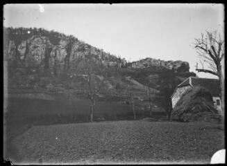 1 vue - Paysage rural avec une bâtisse en pierre et une meule de foin. - [entre 1900 et 1930]. - Photographie (ouvre la visionneuse)
