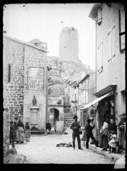 1 vue - Rue de village, avec une tour dans les hauteurs. - [entre 1900 et 1930]. - Photographie (ouvre la visionneuse)