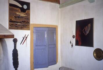 2 vues Vues partielles du salon, avec des peintures au mur.