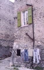 1 vue Villefranche-de-Conflent. Une rue à l'intérieur de la citadelle : maison près d'un rempart, linge étendu sur un fil.