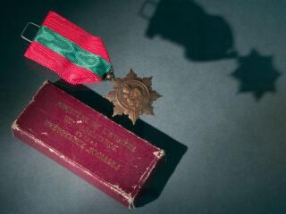 1 vue Médaille de la Famille française. - Encouragement national aux familles nombreuses par le ministère de l'Hygiène, de l'Assistance et de la Prévoyance sociales : étoile à huit branches en bronze de 36 mm (bronze argenté, bronze doré, argent, vermeil ou en or suivant l'échelon), avec une partie centrale ronde. Le Ruban rouge ponceau comporte au centre une raie verticale verte de 11 mm.