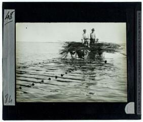 1 vue 48. [Lac côtier des Bibans : deux pêcheurs sur une barque, déployant le filet dit