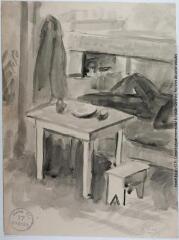 1 vue Le coin repas et nuit : une table avec un banc sur laquelle est posée une assiette et en arrière-plan, une couchette sur laquelle est allongé un homme.